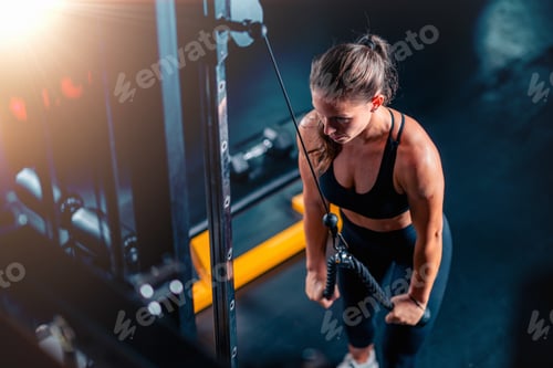 Preview: Engaging with a back cable machine in the gym, a woman improves back power and posture.