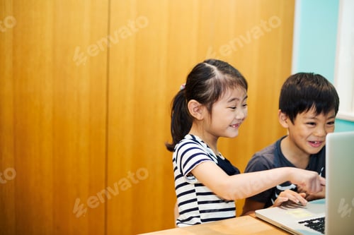 Preview: Two children sharing a laptop computer.