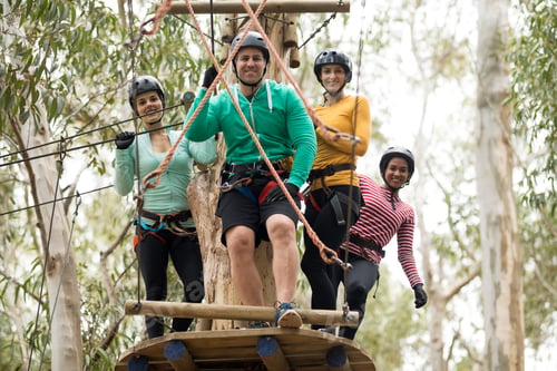 Preview: Friends getting ready to zip line in park on a sunny day