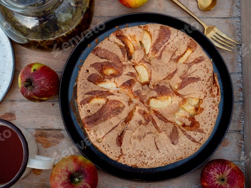 Preview: Apple pie and tea on tray on table in a garden