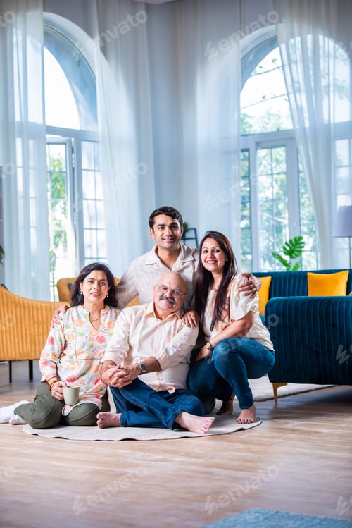 Preview: Portrait of happy Indian family of four sitting in modern living room