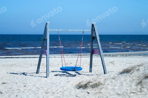 Preview: Beach swings at the sea on a cold spring day