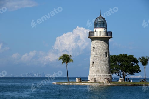 Preview: a lighthouse sitting on top of a body of water next to trees