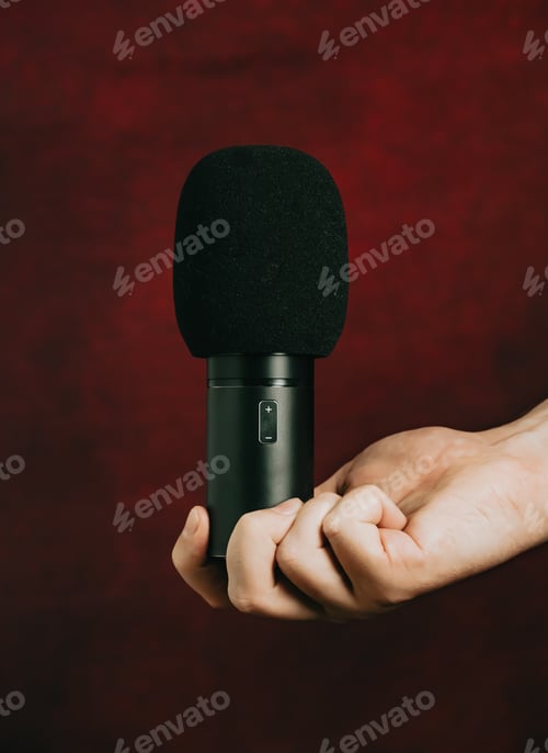 Preview: A hand grabbing a microphone over a red background