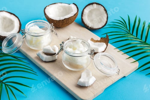 Preview: Coconut pieces on wooden board on blue background