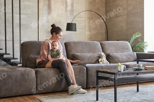 Preview: Young Woman with Disability Holding Baby while Working