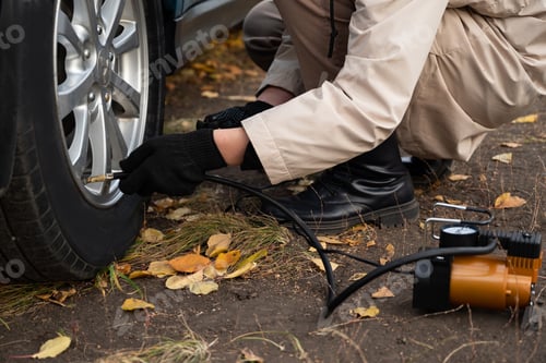 Preview: man driver hand inflating tires of vehicle, removing tire valve nitrogen cap for checking air pressu
