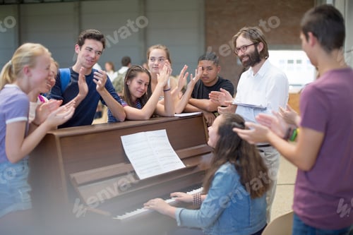 Preview: Teacher with group of students standing around piano and applauding