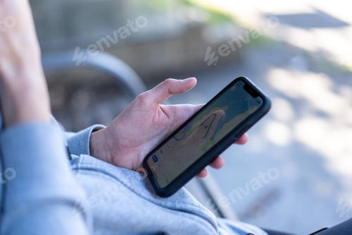 Preview: person looking up navigation on phone while waiting at bus stop, getting correct directions