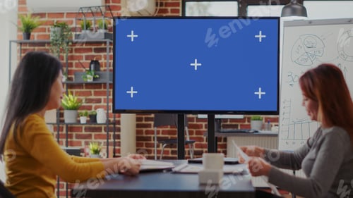 Preview: Team of colleagues looking at mockup template on monitor