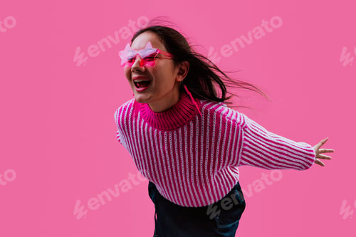 Preview: Young woman showing rock n roll gesture smiling