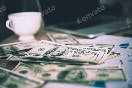 Preview: Working place of trader. The table covered by cash notes, keyboard and financial charts.