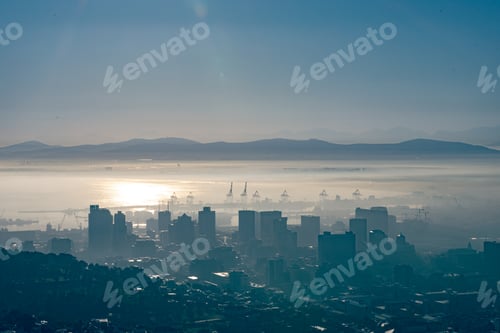 Preview: General view of cityscape with multiple modern buildings and skyscrapers in the foggy morning