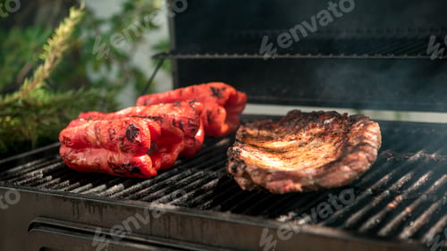Preview: Cooking pork ribs with red peppers on BBQ grill. Cook a delicious grilled meat.