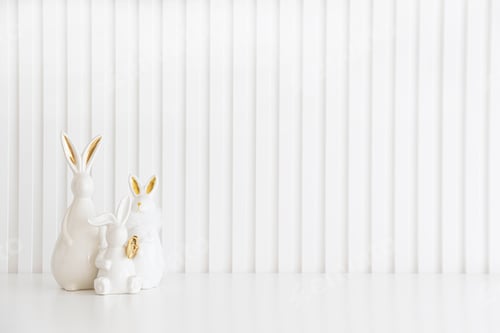 Preview: Easter rabbits figurines and eggs on white background. Easter celebration concept.