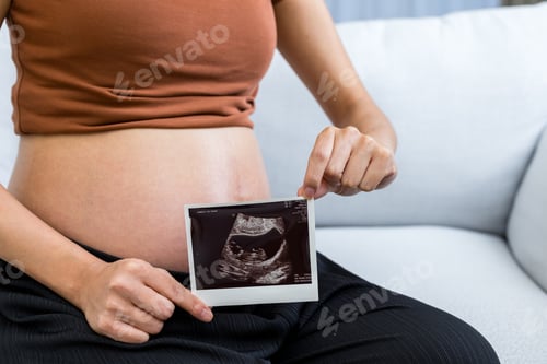 Preview: Pregnant hold with ultrasound baby photo at home