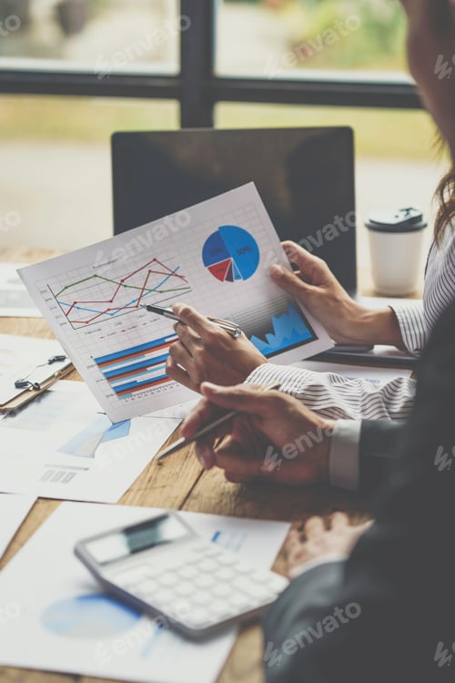 Preview: Business Professionals Analyzing Financial Data at Wooden Desk