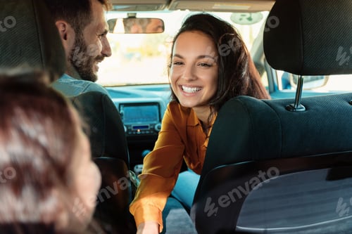 Preview: Young european family sitting in new car, mother smiling and talking to her daughter, enjoying road