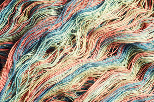 Preview: Threads from natural organic sheep wool. Unwound skein of multicolor rainbow knitting yarn.