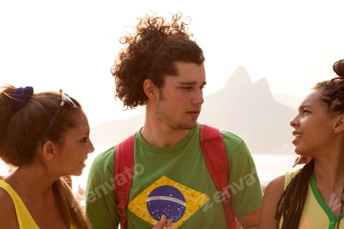 Preview: Three young adult friends chatting on Ipanema beach, Rio De Janeiro, Brazil