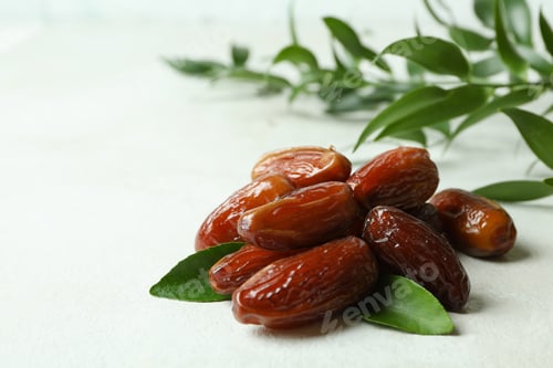 Preview: Dried dates and leaves on white textured background