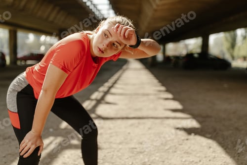 Preview: Tired fitness woman sweating taking a break after difficult training.