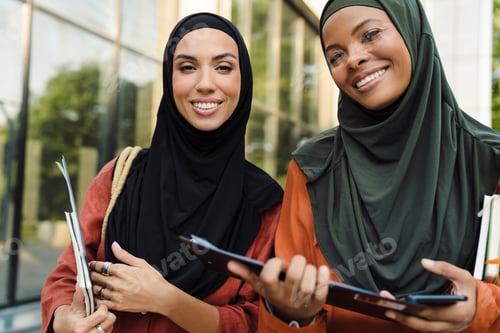 Preview: Multiracial muslim women smiling while standing with clipboard
