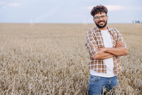Preview: Agronomist standing with crossed arms in wheat field
