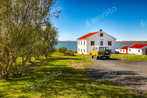 Preview: Beautiful landscape of sunny day at Lake Myvatn with green meadow and nice house