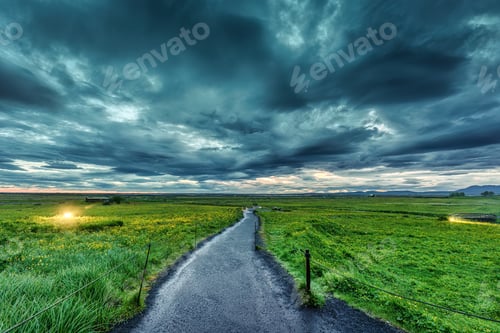 Preview: View of pathway on agricultural field and moody sky in summer