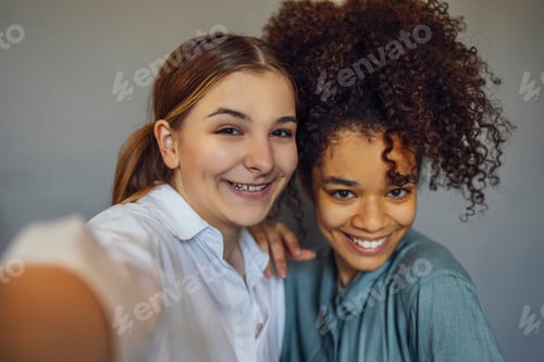 Preview: multi-ethnic best female friends making selfie photo and having fun
