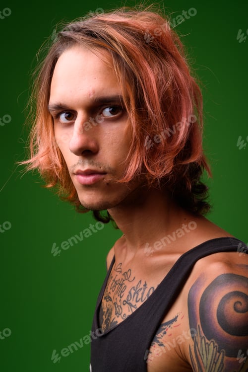 Preview: Studio shot of rebellious young man against green background