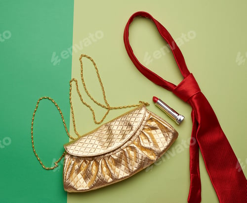 Preview: Golden fashion handbag on a chain and a red silk tie on a green background