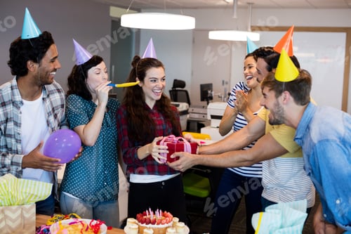 Preview: Creative business team giving a gift to their college on her birthday