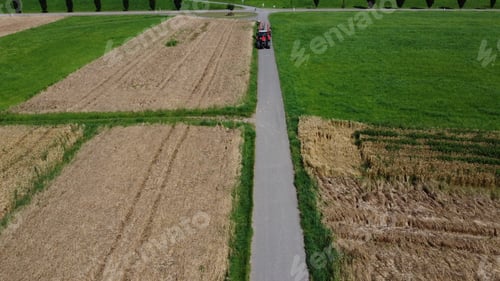 Preview: Bird's eye view of a tractor driving on an asphalt road between green agricultural fields of crops