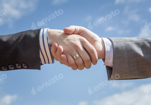 Preview: Closeup of business handshake over sky background