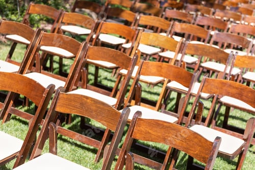 Preview: Rows of Wooden Event Chairs at Wedding Venue Abstract.