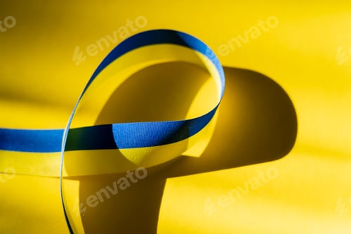 Preview: Close up view of blue and yellow ribbon on background with shadow