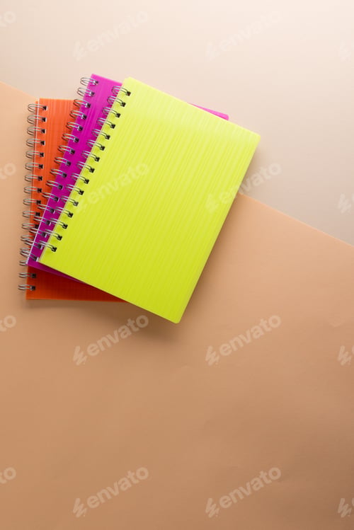 Preview: Flat lay of three notebooks with binding with copy space on orange background