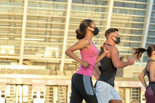 Preview: Young mixed race athletes in masks running sideways
