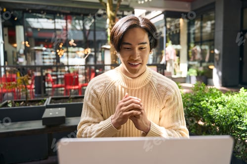 Preview: Smiling asian man using laptop communication online, having video call