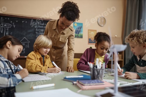 Preview: Female Teacher Helping Group of Kids in School Class