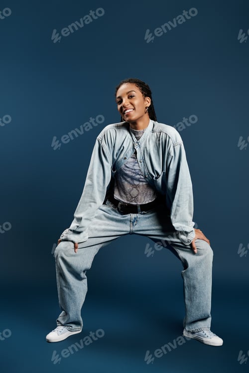 Preview: Stylish young woman showcases modern street fashion with confidence against a vibrant blue backdrop