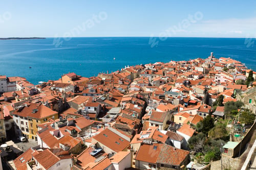 Preview: Aerial view of Piran with red rooftops and sea.