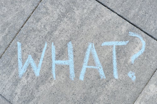 Preview: Abstract what question mark drawn in crayons on gray asphalt