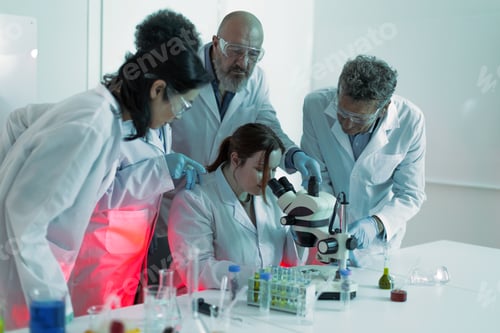 Preview: Diverse team of scientists researching with microscope in laboratory
