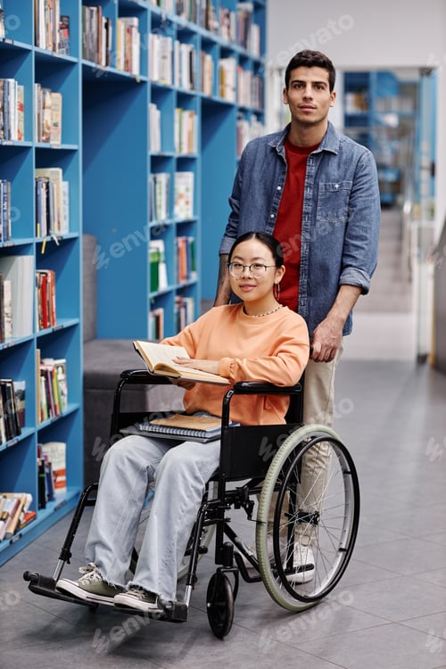 Preview: Smiling young man assisting female student with disability in library