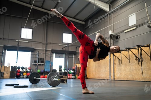 Preview: Sportive woman kicking in the air in a gym