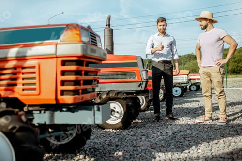 Preview: Agronomist with salesman near the tractor outdoors