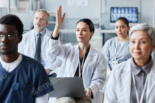 Preview: Young brunette general practitioner raising hand after report of coach